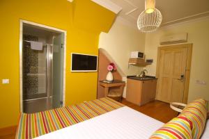 a bedroom with a bed and a yellow wall at Top Flat with Lovely Garden near Hadrian's Gate 