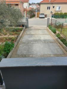 a concrete bench in front of a driveway at The Nice Dreams Studio Apartment in Zadar