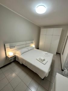 a bedroom with a white bed with two towels on it at Dreaming Borgo Roma Apartment in Verona