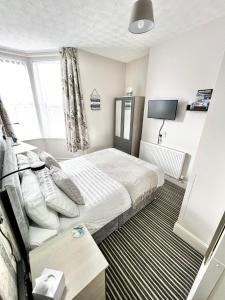 a hotel room with a bed and a tv at Belle Dene Guest House in Paignton