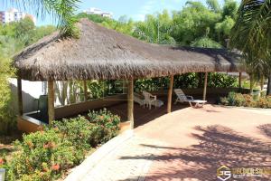 a hut with a straw roof and a patio at Flats CTC Araras in Caldas Novas
