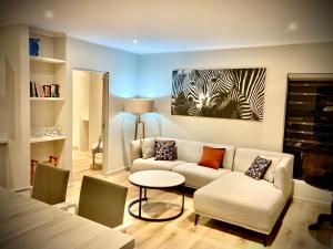 a living room with a couch and a zebra painting at Tonquani - Knysna (est. 2022) in Knysna
