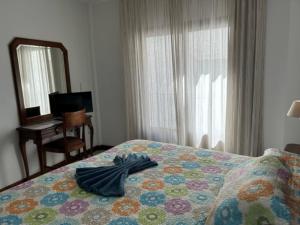 a bedroom with a bed with a blue robe on it at Hotel Al-Andalus in Torrox