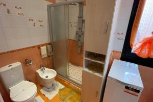 uma casa de banho com um WC, um chuveiro e um lavatório. em i tulipani em Miagliano