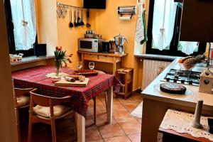 a kitchen with a table with a red table cloth at i tulipani in Miagliano