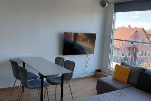 a living room with a table and chairs and a tv at Fiume Panorama Residence with free garage in Budapest