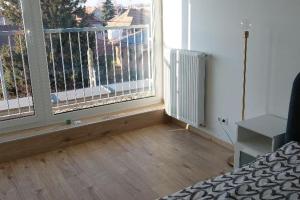 a bedroom with a large window and a radiator at Fiume Panorama Residence with free garage in Budapest