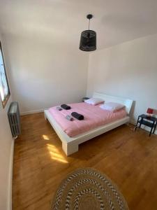 um quarto com uma cama com lençóis e almofadas cor-de-rosa em Logement entier dans maison - Passy - 6 personnes em Passy