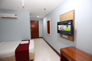 sypialnia z łóżkiem i telewizorem na ścianie w obiekcie LA ISRA at KL w Kuala Lumpur