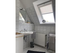 łazienka z umywalką, wanną i oknem w obiekcie Ankerplatz10 w mieście Varel