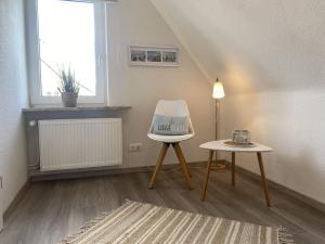 una camera con una sedia bianca e un tavolo di Ankerplatz10 a Varel