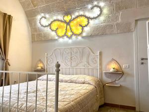 a bedroom with a white bed with a butterfly chandelier at Il Pumo Rosa - Puglia Mia Apartments in Monopoli