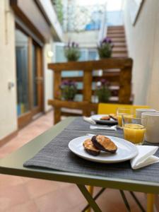 a table with a plate of biscuits and orange juice at Chic apartment beach in Mataró