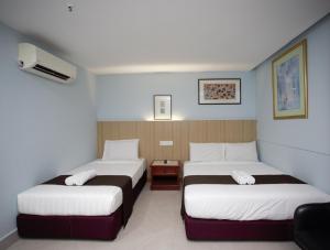 クアラルンプールにあるLA ISRA at KLの白と茶色のシーツが備わるベッド2台が備わる客室です。