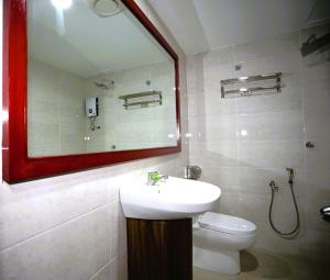 W łazience znajduje się umywalka, toaleta i lustro. w obiekcie LA ISRA at KL w Kuala Lumpur