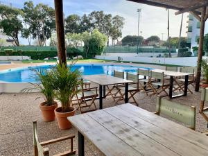 eine Terrasse mit Tischen und Stühlen neben einem Pool in der Unterkunft Ma vue mer en Algarve in Portimão