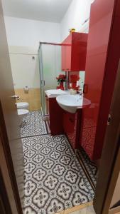 baño con 2 lavabos y armarios rojos en Casa 2D, en San Vito Chietino