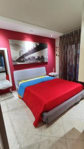 1 dormitorio con 1 cama grande y pared roja en Casa 2D, en San Vito Chietino