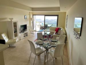 sala de estar con mesa y sillas en Superior apartment for golf, sea and nature lovers, en Casares