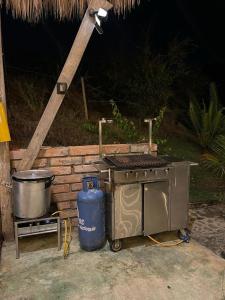 uma grelha e uma lata de lixo ao lado de uma parede de tijolos em finca playa seca em Santa Fe de Antioquia