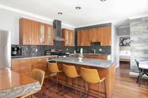 eine Küche mit Holzschränken und einer Insel mit Barhockern in der Unterkunft Riverfront Penthouse Suite in Midtown Harrisburg near Hershey in Harrisburg