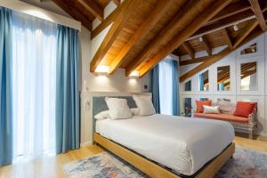 1 dormitorio con 1 cama blanca grande y cortinas azules en Hotel Sol Boutique en Santander