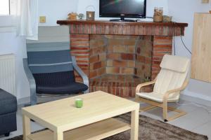 a living room with two chairs and a fireplace at Cool Breeze Apartment in Maçanet de Cabrenys