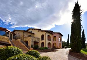 a villa with a palm tree and a driveway at Borgobrufa Spa Resort Adults Only in Brufa