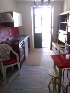 a kitchen with a stove and a door to a room at La taverna in Sessa