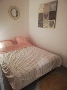 a bedroom with a bed with a comforter on it at Joli appartement climatisé proche plage et port in Sanary-sur-Mer