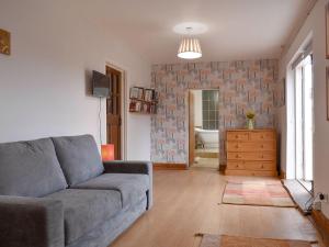 a living room with a couch and a bathroom at Middle Farm in East Harling