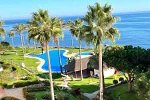 una vista aerea di un resort con palme e oceano di MI CAPRICHO 9A BEACHFRONT- Apartment with sea view - Costa del Sol a Sitio de Calahonda
