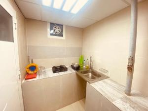 una pequeña cocina con fregadero y encimera en Farmhouse One Bedroom Attached Bathroom, en Al Rahba