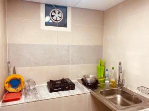a kitchen counter with a sink and a stove at Farmhouse One Bedroom Attached Bathroom in Al Rahba
