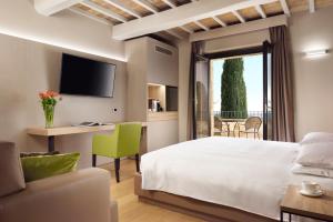 una camera con letto, scrivania e TV di Borgobrufa Spa Resort Adults Only a Brufa