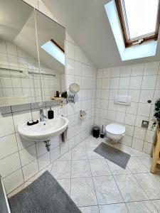 uma casa de banho com um lavatório e um WC em Ferienwohnung Haus Reindl em Walchensee