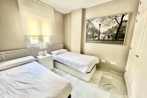 a bedroom with two beds and a picture on the wall at MI CAPRICHO 9B BEACHFRONT- Apartment with sea view - Costa del Sol in Mijas Costa +54 photos