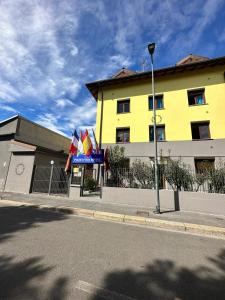 a yellow building with flags on the side of a street at Residence Politecnico Bovisa in Milan