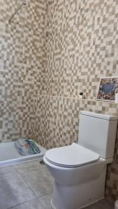 a bathroom with a white toilet and a bath tub at Club praia da Rocha III in Portimão