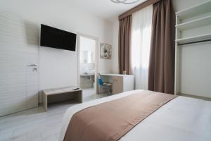 Habitación de hotel con cama y TV en VeMi Affittacamere, en Posada