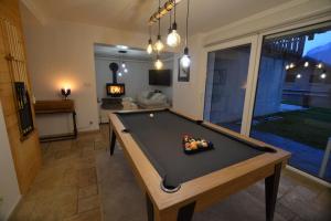 a pool table in a living room with a pool table at Chalet le Vertical - Chalet5*, sauna, jacuzzi, billard, balnéo, massage, pistes à 150 m in Les Deux Alpes