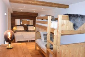 a room with two bunk beds and a table at Chalet le Vertical - Chalet5*, sauna, jacuzzi, billard, balnéo, massage, pistes à 150 m in Les Deux Alpes