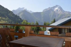 a wooden deck with a view of mountains at Chalet le Vertical - Chalet5*, sauna, jacuzzi, billard, balnéo, massage, pistes à 150 m in Les Deux Alpes