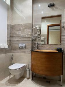 een badkamer met een toilet, een wastafel en een spiegel bij Hotel Bistrik City Center in Sarajevo