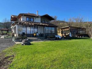 a large house with a large lawn in front of it at Vila Marina Ilkoni at Jrebchevo dam in Kriva Krusha