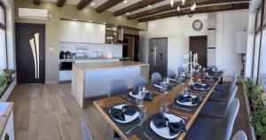 a dining room with a table and chairs and a kitchen at Vila Marina Ilkoni at Jrebchevo dam in Kriva Krusha