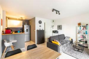 sala de estar con sofá y cocina en Appartement T2 40 m2 - Tout équipé et calme, en Toulouse