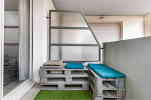Appartement T2 40 m2 - Tout équipé et calme في تولوز: شرفة مع مقعد ونافذة مع العشب الأخضر