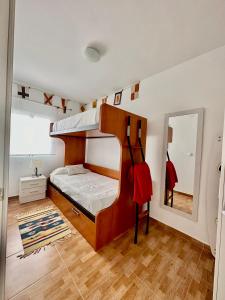 a bedroom with a bunk bed and a mirror at Casita de Bolonia in Bolonia