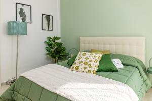 um quarto com uma cama com um edredão verde e branco em Vesuvio Casa de Charme em Trecase